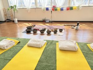 シンギングボウルとヨガマットのある静かないわきスタジオ